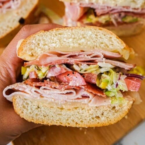 Sandwich on a bun with deli meat and lettuce.